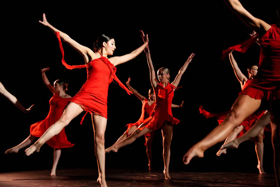 WVU Student Dance Association dancing in sync wearing matching red dresses.