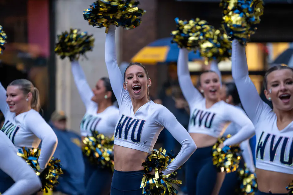 The WVU Cheer Team marching in the WVU Homecoming Parade on High Street Morgantown, WV.