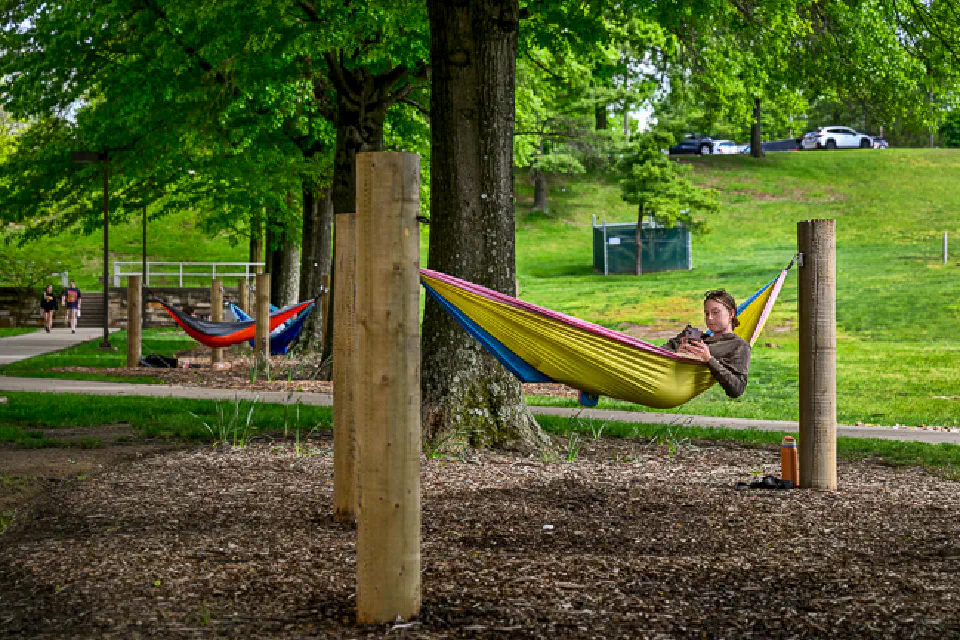 Student relaxing in hammock outside the Evansdale Residential Complex