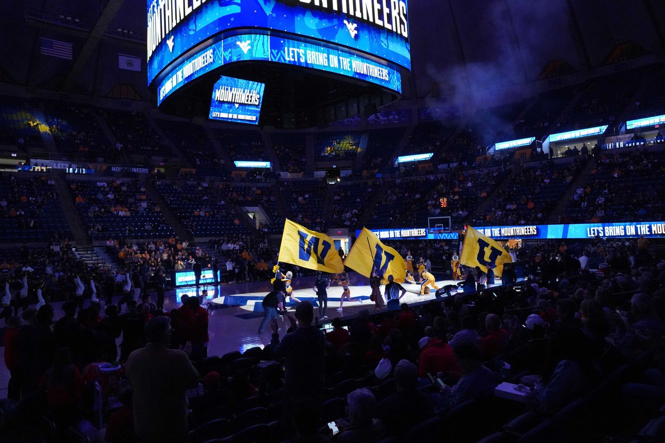 Cheerleaders carry the W-V-U flags onto the court for pregame at the WVU Coliseum.